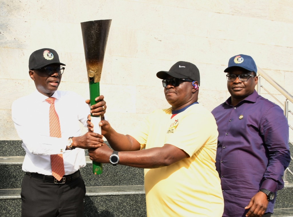 L-R: Lagos State Governor, Mr. Babajide Sanwo-Olu, receiving the Unity Torch from representative of Minister of Youth and Sport and Co-ordinator, South West Zone 1, Mr. Femi Ajao while the Commissioner for Youth and Social Development, Mr. Segun Dawodu, watches on during the presentation of the National Sport Festival “Edo 2020” Unity Torch to the Governor, at the Lagos House, Alausa, Ikeja, on Thursday, March 12, 2020.