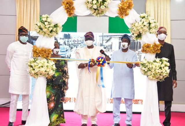 Lagos State Governor, Mr. Babajide Sanwo-Olu (middle), cutting the tape to commission vital and various project (Classroom blocks in different Primary and Secondary Schools; Housing Schemes at Igbogbo-Ikorodu and Topo-Badagry; Intelligent Transportation System (ITS) for Bus Reform Scheme at different bus terminals; rehabilitated roads in LGs and Concrete jetty with shoreline protection at Baiyeku, Ikorodu) to commemorate his administration’s First Year in Office, at Lagos House, Marina, on Friday, May 29, 2020. With him: Deputy Governor, Dr. Obafemi Hamzat (second right); Chief of Staff to the Governor, Mr. Tayo Ayinde (right); Secretary to the State Government, Mrs. Folasade Jaji (second left) and the Head of Service, Mr. Hakeem Muri-Okunola (left).