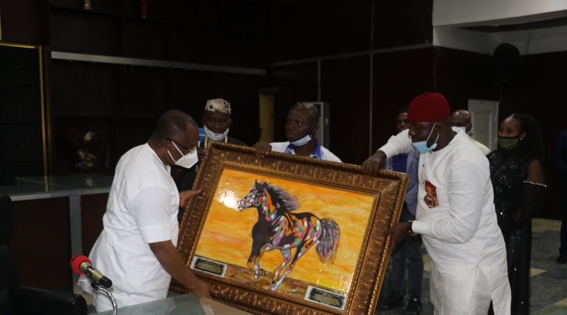 Governor Uzodimma receiving an Artwork painting from Dart-Chas Innocent of Dart-Chas-Integrated Services (DCIS) at the Govt. House, Owerri.