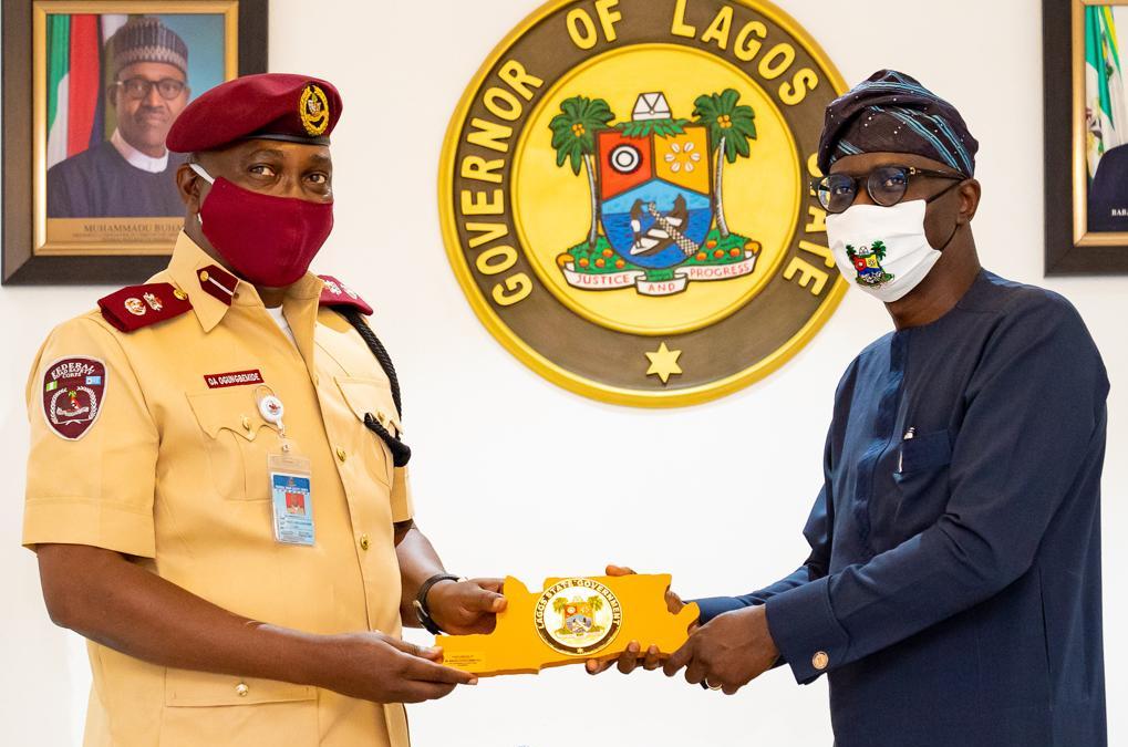 L-R: Sector Commander, Federal Road Safety Corps (FRSC) in charge of Lagos, Mr. Olusegun Ogungbemide, receiving a souvenir from Lagos State Governor, Mr. Babajide Sanwo-Olu during a courtesy call on the Governor, at Lagos House, Marina, on Thursday, July 23, 2020.