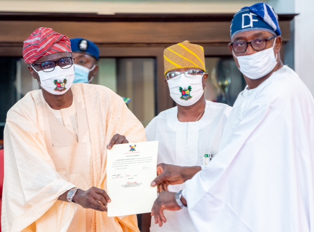 L-R: Lagos State Governor, Mr. Babajide Sanwo-Olu, presenting the Oath of Allegiance to Mr. David Famuyiwa as the new Chairman of Agbado-Oke Odo LCDA, while Commissioner for Local Government and Community Affairs, Dr. Wale Ahmed, watches, during the swearing-in of the new Chairman of Agbado-Oke Odo LCDA, at Lagos House, Alausa, Ikeja, on Tuesday, June 30, 2020.