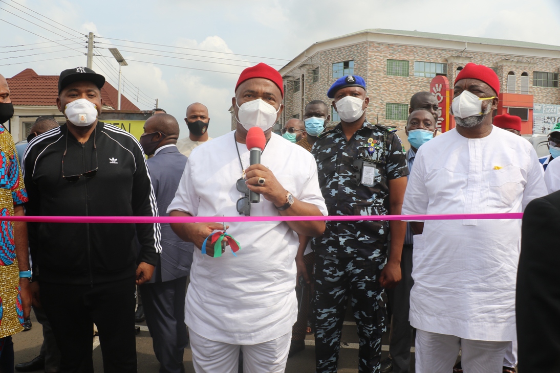 Gov Hope Uzodimma cutting the tape to Commission one of the new roads in Owerri, flanked by Chief Emeka Wogu, CON(R) and Chief of Staff Barr Nnamdi Anyaehie (L)